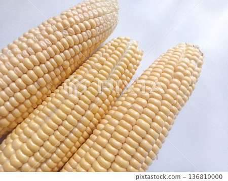 Four fresh corn cobs with plump yellow kernels, neatly arranged and perfect for agriculture, food, and nutrition. Four fresh corn cobs with plump yellow kernels, neatly arranged and perfect for agriculture, food, and nutrition. 136810000