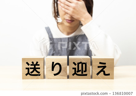 A woman wearing an apron and a block with the words "Pick-up and drop-off" written on it 136810007