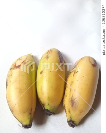 Three ripe bananas with yellow peels and natural brown spots, fresh tropical fruit perfect for healthy eating. Three ripe bananas with yellow peels and natural brown spots, fresh tropical fruit perfect for healthy eating. 136810374