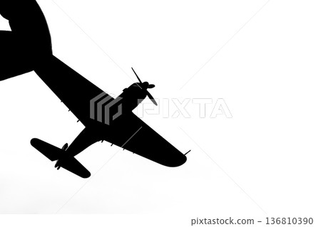 Silhouette of a propeller fighter plane pinched between fingers Silhouette of a propeller fighter plane pinched between fingers 136810390