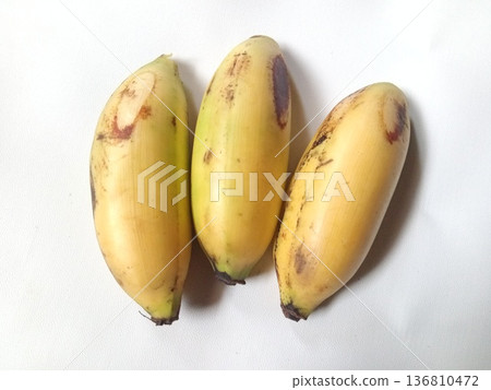 Three ripe bananas with yellow peels and natural brown spots, tropical fruit perfect for healthy eating. Three ripe bananas with yellow peels and natural brown spots, tropical fruit perfect for healthy eating. 136810472