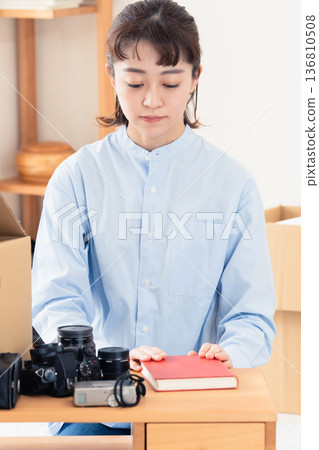 一位女士正在整理不需要的物品。 136810508