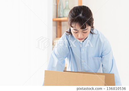 A woman sorting out unnecessary items A woman sorting out unnecessary items 136810536