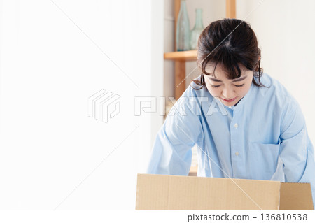 A woman sorting out unnecessary items A woman sorting out unnecessary items 136810538