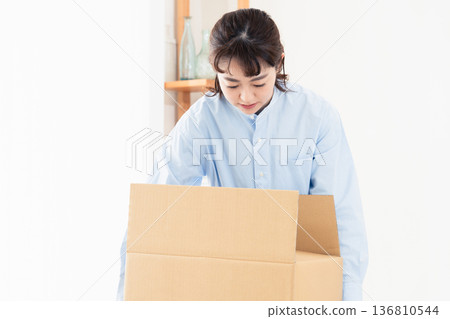 A woman sorting out unnecessary items A woman sorting out unnecessary items 136810544
