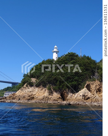 在晴朗的日子裡，從海上可以看到小島上的白色燈塔。 136811531