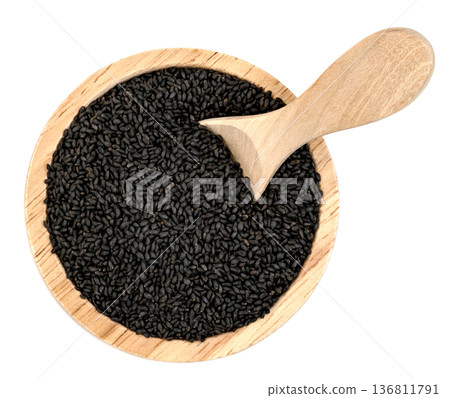 Top view of black basil seeds in a round wooden bowl with a wooden scoop. Healthy organic superfood, sabja seeds, isolated. Professional food photography for spice packaging. 136811791