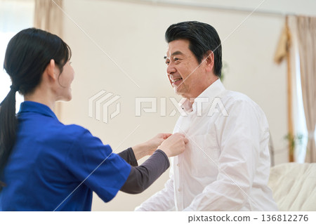 亞洲護理員在家庭護理探訪期間扣襯衫紐扣 136812276