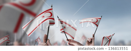 Northern Cyprus flags in their hands on a blurred urban background 136813551