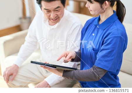 一位護理人員使用平板電腦管理居家護理 136815571