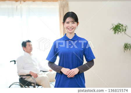 Asian female caregiver standing with a smile Asian female caregiver standing with a smile 136815574