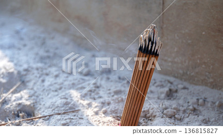 一束束香燭立於香盤的沙土中,靜靜地裊裊升起。 一束束香燭立於香盤的沙土中,靜靜地裊裊升起。 136815827