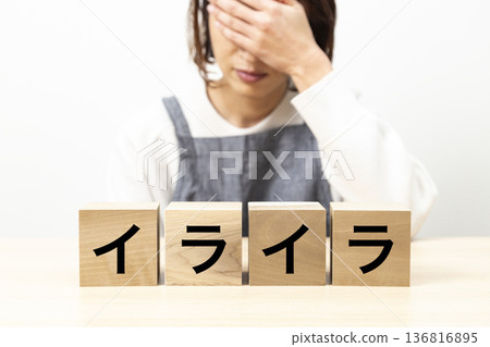 A woman in an apron with a block that says "irritated" 136816895
