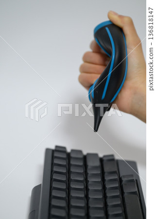 Close-up of hand cleaning keyboard with blower Close-up of hand cleaning keyboard with blower 136818147