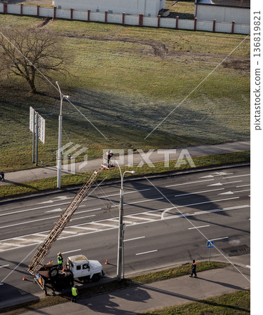 Electrician repairing the street light. Electrician repairing the street light. 136819821