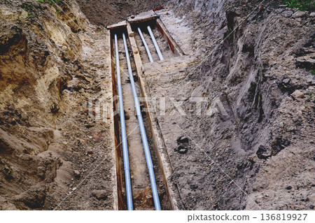 Dug hole for repair plastic metal water sewer pipes  136819927