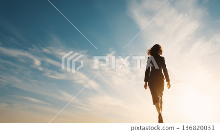 Full-body photo of a businesswoman walking with blue sky and clouds in the background Full-body photo of a businesswoman walking with blue sky and clouds in the background 136820031