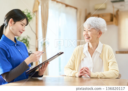 Senior woman being interviewed by a caregiver Senior woman being interviewed by a caregiver 136820117