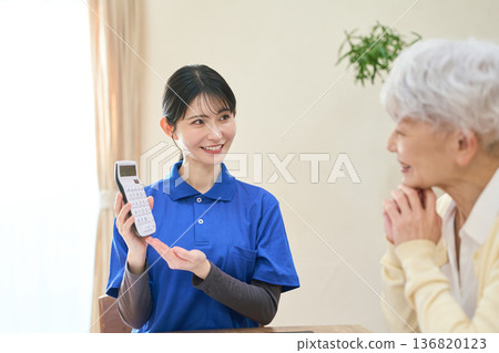 Asian caregiver estimating care costs Asian caregiver estimating care costs 136820123