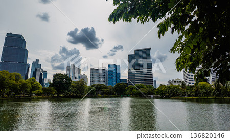 modern green park with lake and skyscraper buildings view, city reflection in pond water, Lumpini, Bangkok modern green park with lake and skyscraper buildings view, city reflection in pond water, Lumpini, Bangkok 136820146