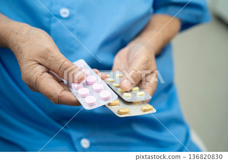 Asian elderly woman holding pill drug in hand, strong healthy medical concept. Asian elderly woman holding pill drug in hand, strong healthy medical concept. 136820830