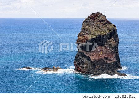 From a coastal lookout a volcanic sea stack near Ribeira da Janela rises above surf in summer light From a coastal lookout a volcanic sea stack near Ribeira da Janela rises above surf in summer light 136820832