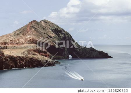 Vintage view of Ponta de Sao Lourenco cliffs with calm Atlantic and a speedboat leaving pale wake 136820833