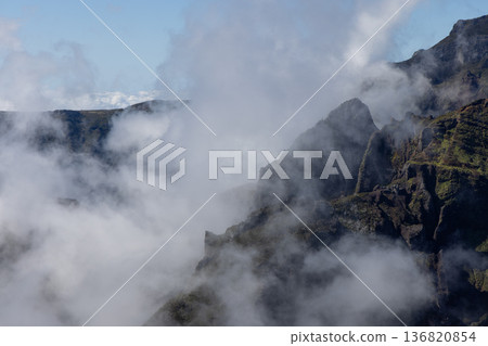 From PR1 trail jagged cliffs rise above Curral das Freiras as morning fog veils green ridges Madeira 136820854