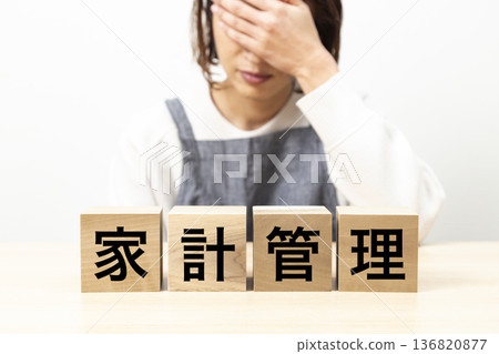 一位身穿圍裙、手持寫有「家務管理」字樣木塊的婦女 136820877