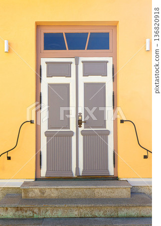 Traditional residential entrance with colorful yellow wall and steps Traditional residential entrance with colorful yellow wall and steps 136820918