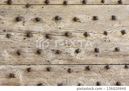 Weathered wooden door planks with rustic metal studs Weathered wooden door planks with rustic metal studs 136820948