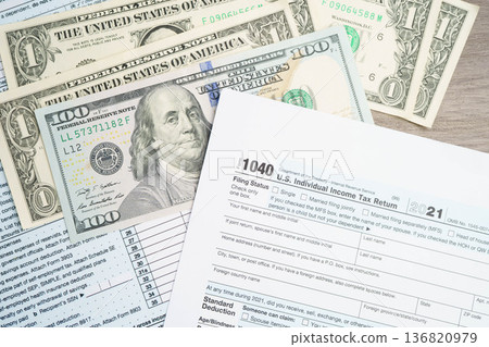Tax form 1040 U.S. Individual Income Tax Return with dollar banknotes money. 136820979