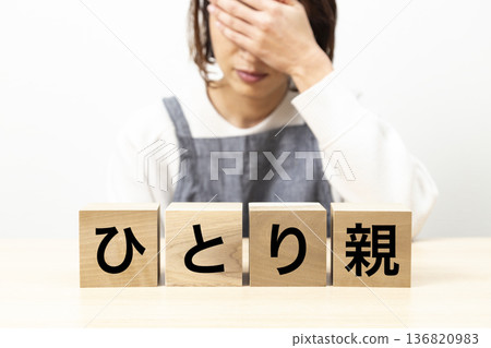 A woman wearing an apron and a block that reads "single parent" A woman wearing an apron and a block that reads "single parent" 136820983