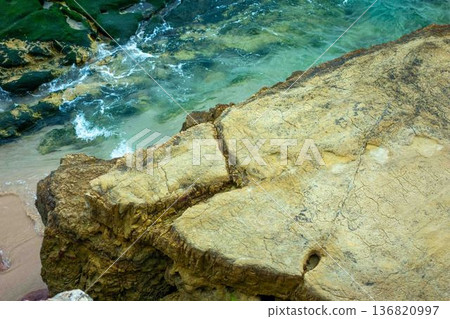 Dinosaur footprints on a rocky plateau by beautiful ocean Southern Portugal Salema Beach Dinosaur footprints on a rocky plateau by beautiful ocean Southern Portugal Salema Beach 136820997