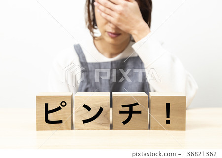 一位穿著圍裙的女士，圍裙上印著「遇到麻煩了！」的字樣。 136821362