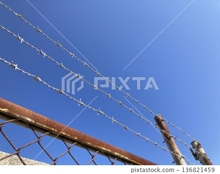 預防犯罪，禁止擅入，鋒利的鐵絲網和鏽跡斑斑的圍欄遮蔽了藍天，劃定了邊界線，營造出封閉的環境。 136821459