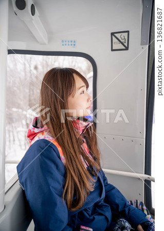 Young woman riding a vehicle to enjoy winter sports 136821687