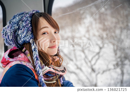 Young woman riding a vehicle to enjoy winter sports 136821725