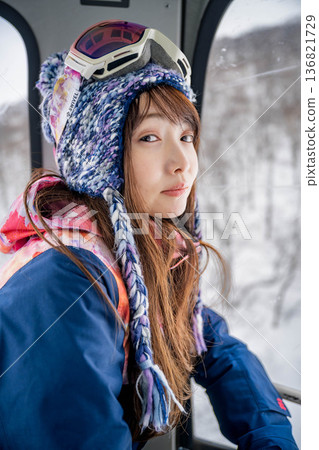 Young woman riding a vehicle to enjoy winter sports 136821729