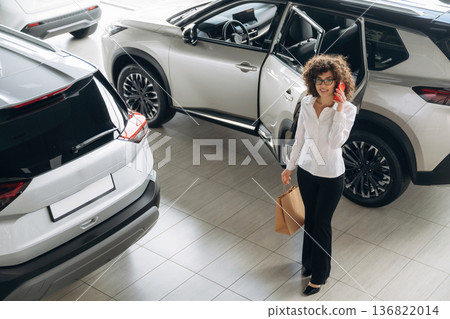 Far top view. Pretty woman is in the car retail shop 136822014