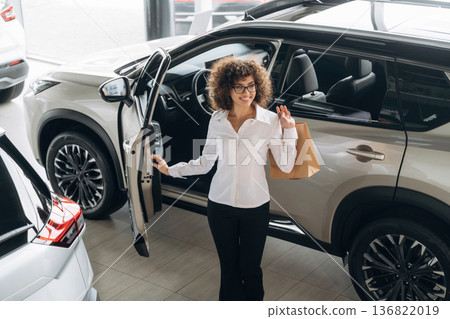 Walking out from vehicle, doors is opened. Pretty woman is in the car retail shop Walking out from vehicle, doors is opened. Pretty woman is in the car retail shop 136822019