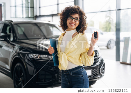 In casual clothes, with keys in hand. Pretty woman is in the car retail shop In casual clothes, with keys in hand. Pretty woman is in the car retail shop 136822121