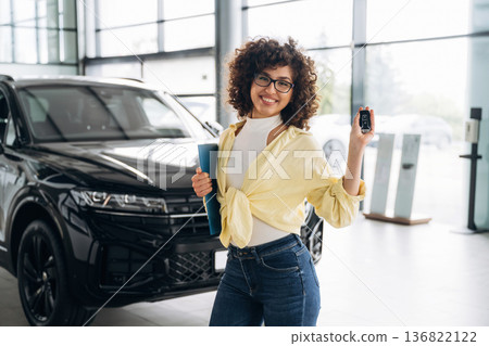In casual clothes, with keys in hand. Pretty woman is in the car retail shop In casual clothes, with keys in hand. Pretty woman is in the car retail shop 136822122