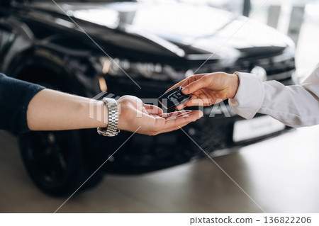 Detailed view of hands of customer that is taking keys for new purchased car Detailed view of hands of customer that is taking keys for new purchased car 136822206