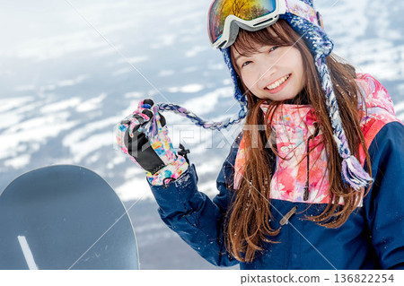 Young woman enjoying snowboarding at the top of the slope Young woman enjoying snowboarding at the top of the slope 136822254