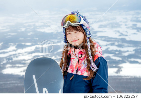 年輕女子在山坡頂端享受滑雪的樂趣 年輕女子在山坡頂端享受滑雪的樂趣 136822257