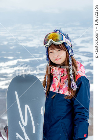 年輕女子在山坡頂端享受滑雪的樂趣 136822258