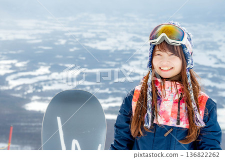 年輕女子在山坡頂端享受滑雪的樂趣 年輕女子在山坡頂端享受滑雪的樂趣 136822262