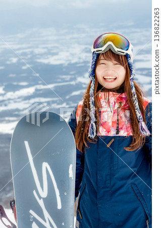 年輕女子在山坡頂端享受滑雪的樂趣 年輕女子在山坡頂端享受滑雪的樂趣 136822263