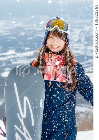 年輕女子在山坡頂端享受滑雪的樂趣 年輕女子在山坡頂端享受滑雪的樂趣 136822265